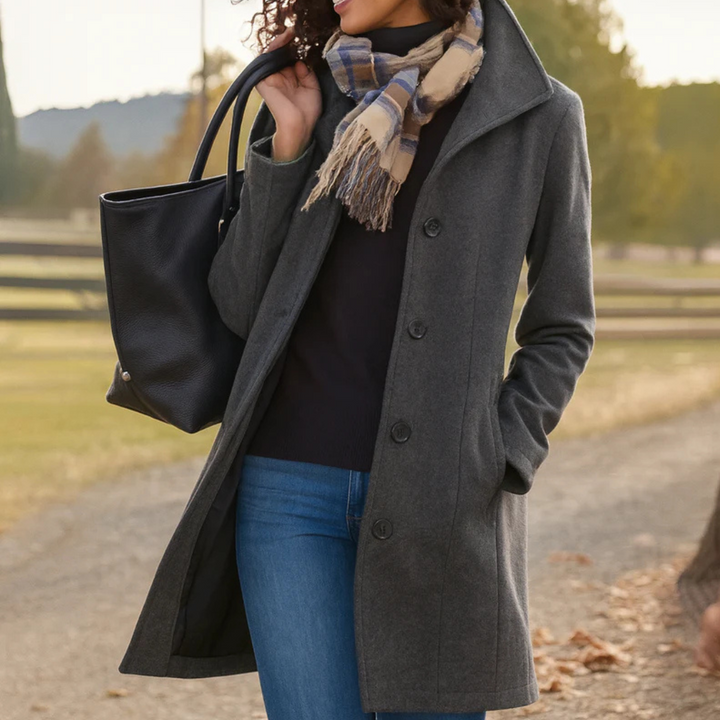 Charcoal grey mid-length button-up winter coat with a structured collar, side pockets, and a tailored fit.