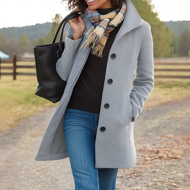 Light grey mid-length button-up winter coat with a structured collar, side pockets, and a tailored silhouette.