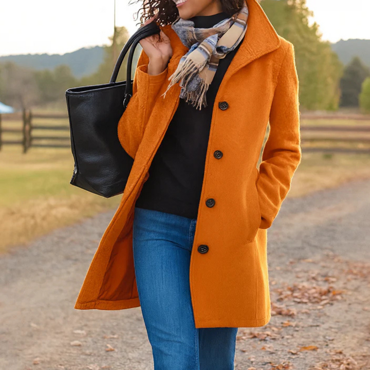 Woman wearing a vibrant orange, mid-length button-up winter coat with a structured collar and side pockets.
