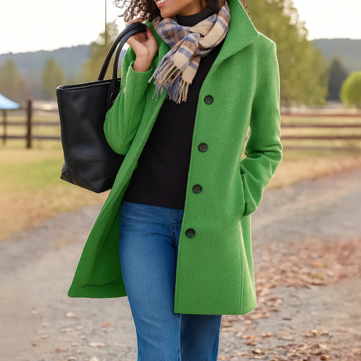 Woman wearing a vibrant green mid-length button-up winter coat with a structured collar, side pockets, and a black leather tote.