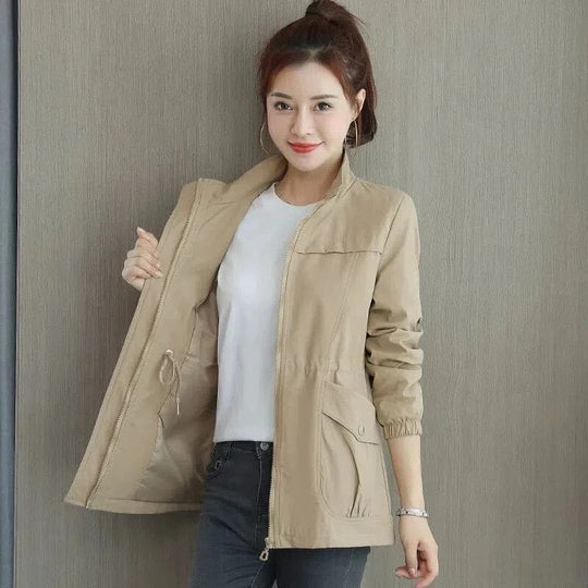 Beige lightweight women's jacket with a stand-up collar, full zip front, and an adjustable drawstring waist.