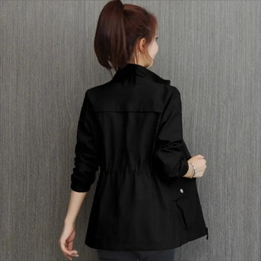 Black lightweight Eleanor jacket with a stand-up collar and adjustable drawstring waist, shown from the back.