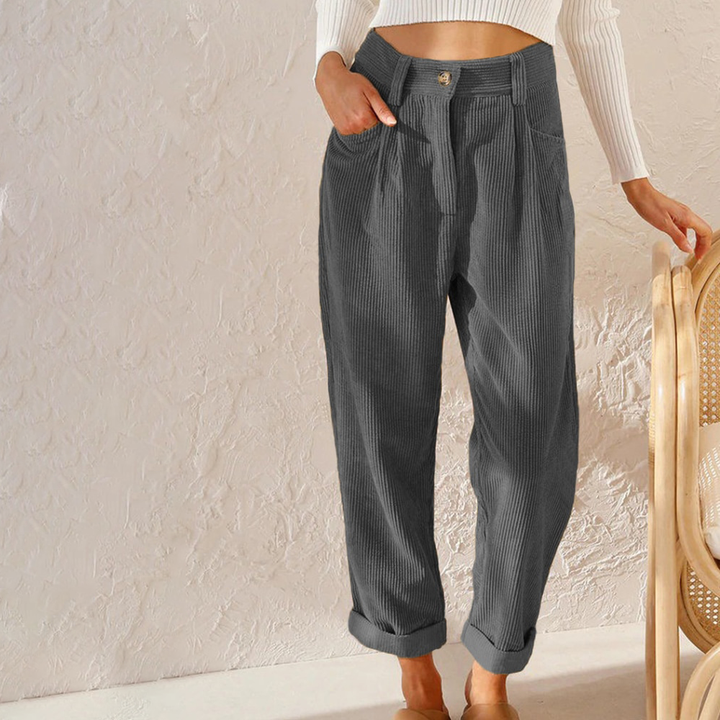 Charcoal grey high-waisted corduroy trousers with a relaxed fit, button-front closure, and rolled-up hems.