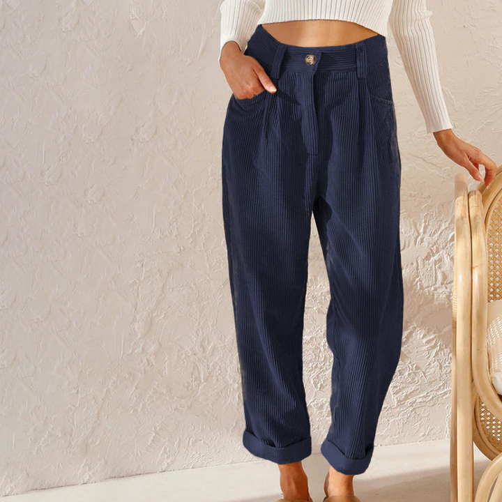 Navy blue high-waisted corduroy trousers with a relaxed fit, button front, and cuffed hems.