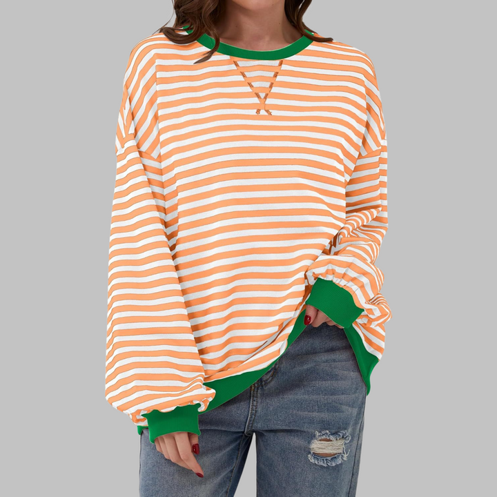 Oversized orange and white striped sweatshirt with a green ribbed crew neckline, cuffs, and hem.