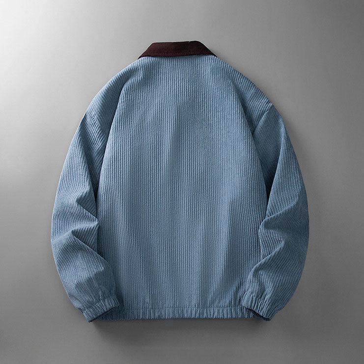 Back view of a blue corduroy zip-up jacket with a contrasting dark brown collar and elasticated hem.