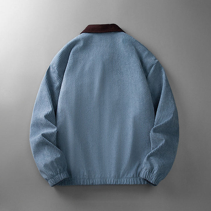 Back view of a blue corduroy zip-up jacket with a contrasting dark brown collar and elasticated hem.
