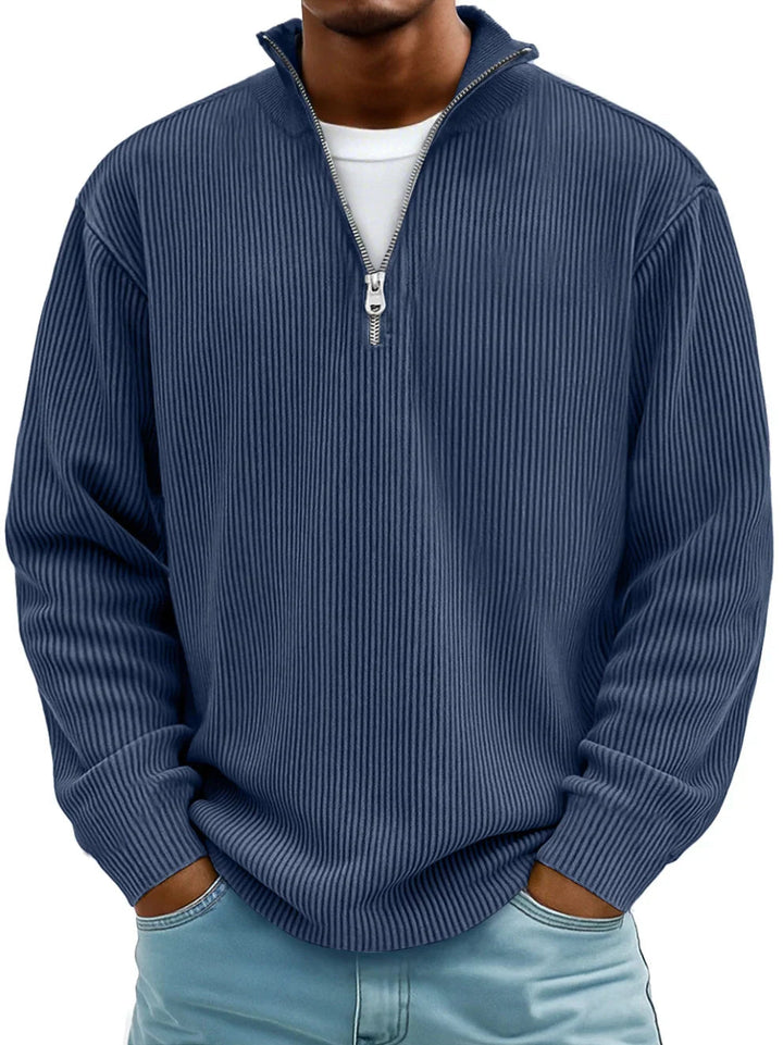 Men's navy blue ribbed half-zip sweater with a stand collar and relaxed fit, worn over a white t-shirt.