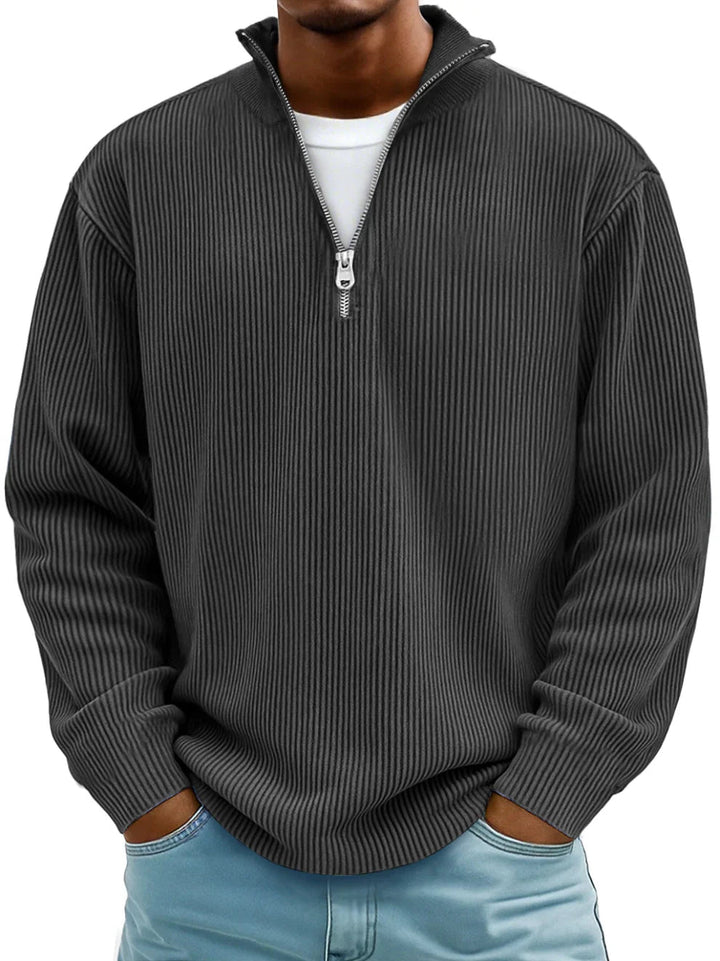 Charcoal grey men's ribbed half-zip sweater with a stand collar and relaxed fit, worn over a white t-shirt.