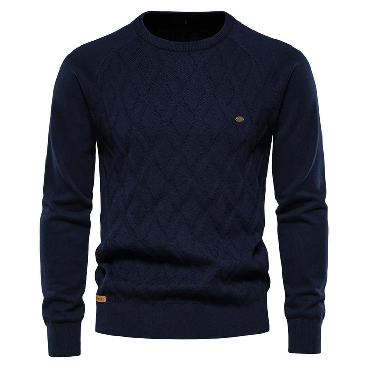Navy blue men's crew neck jumper featuring a textured diamond-knit pattern, ribbed cuffs, and a small chest logo detail.