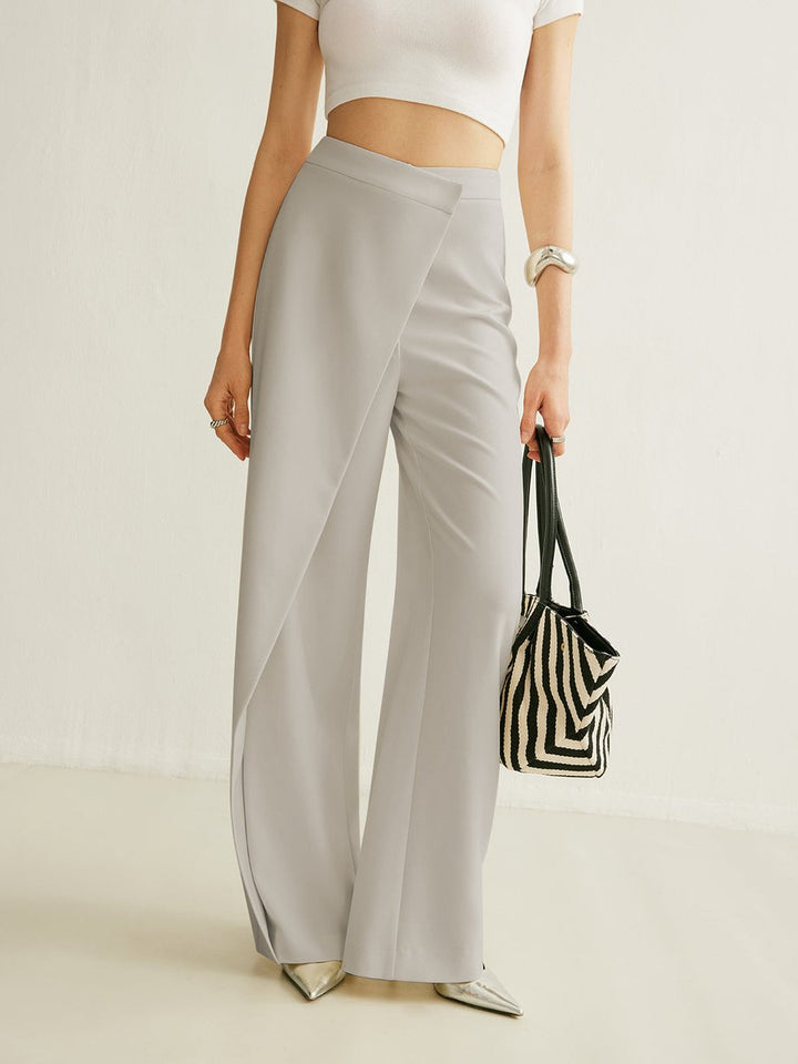 Light grey high-waisted wide-leg trousers featuring a modern asymmetric wrap front panel and a smooth, tailored finish.