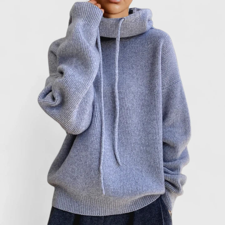 Oversized blue knit jumper featuring a slouchy cowl hood with drawstring, drop shoulders, and ribbed cuffs.