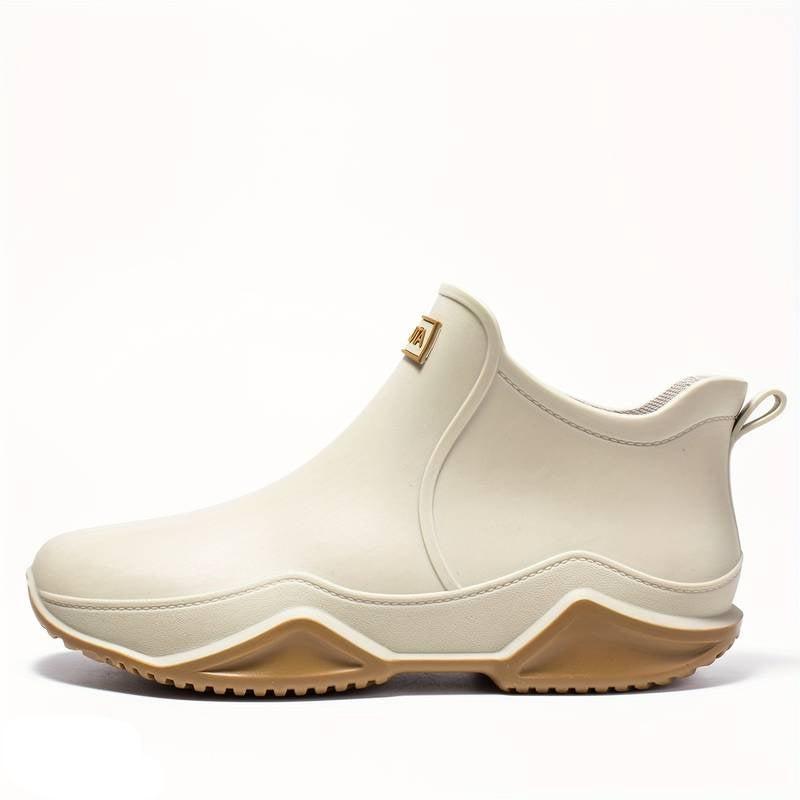 Cream waterproof Elodie ankle rain boots featuring a sleek slip-on design and a chunky, grippy wave-tread gum sole.