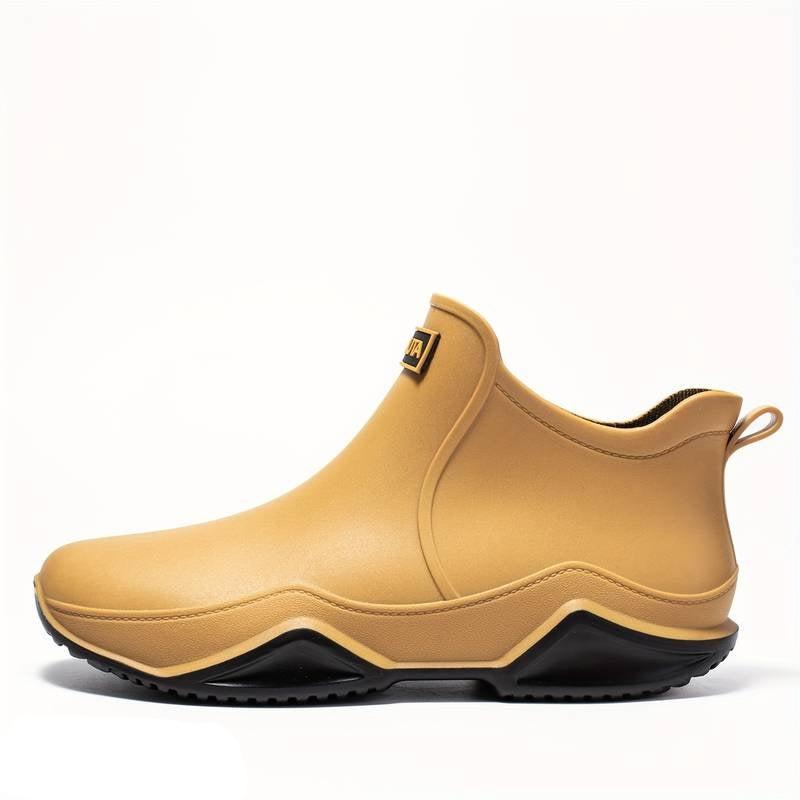 Tan waterproof slip-on ankle rain boots featuring a chunky black wave-tread outsole for superior grip on wet surfaces.