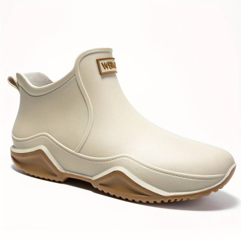Beige waterproof Elodie ankle rain boots with a slip-on design and chunky, grippy wave-tread sole for wet weather.