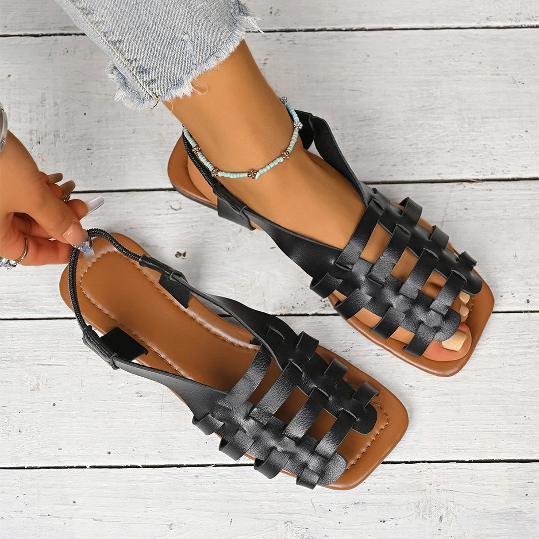 Black woven leather fisherman flat sandals with a brown sole and slingback strap.