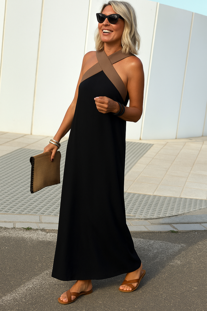 Elsie black maxi dress with a flattering crossover neckline, flowing silhouette, and brown halter straps.