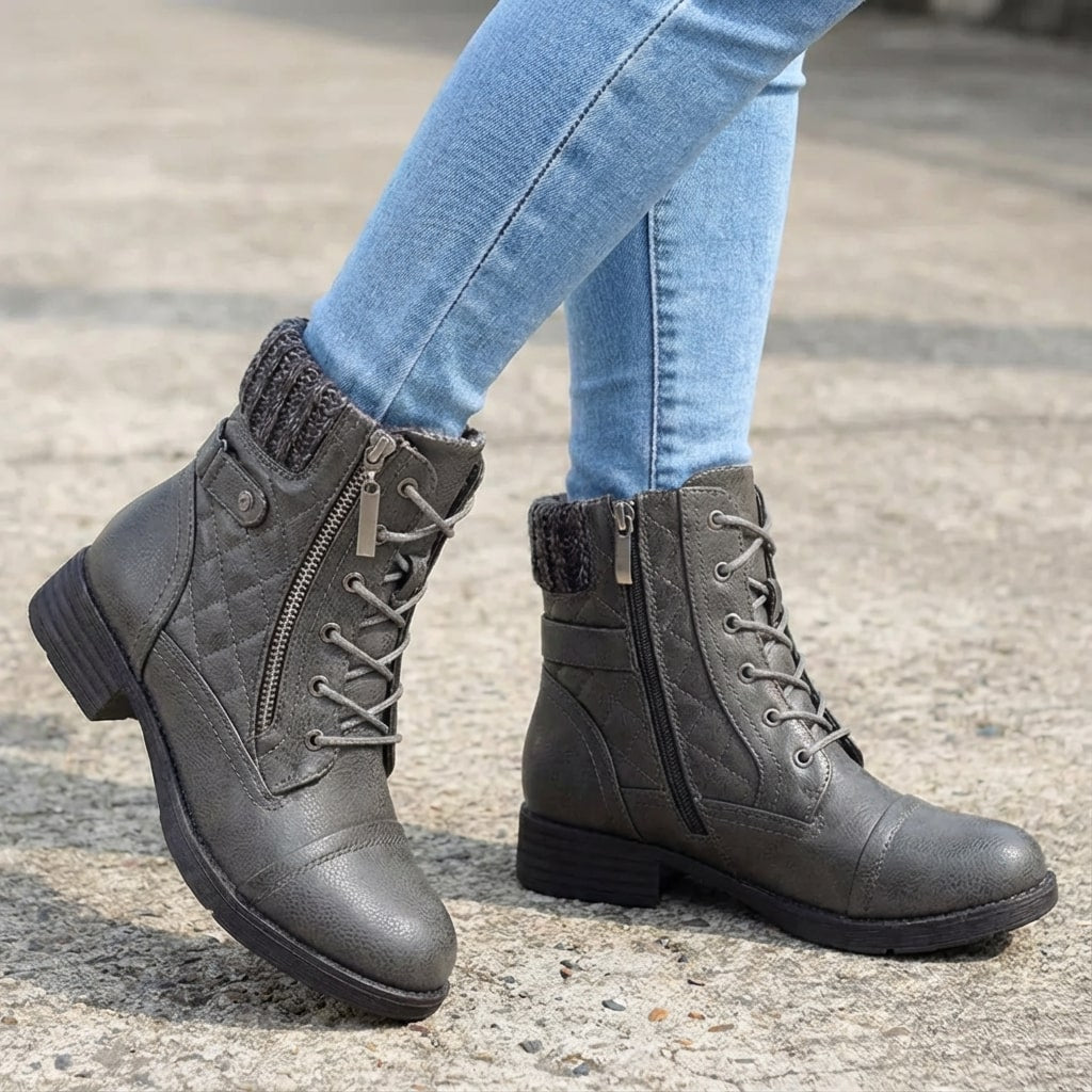 Grey faux leather ankle boots with quilted panels, lace-up front, side zip, and a cozy knitted collar on a low block heel.