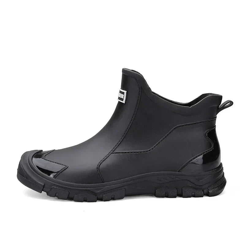 Black waterproof ankle rain boots with a rugged treaded sole and convenient rear pull tab for easy wear.