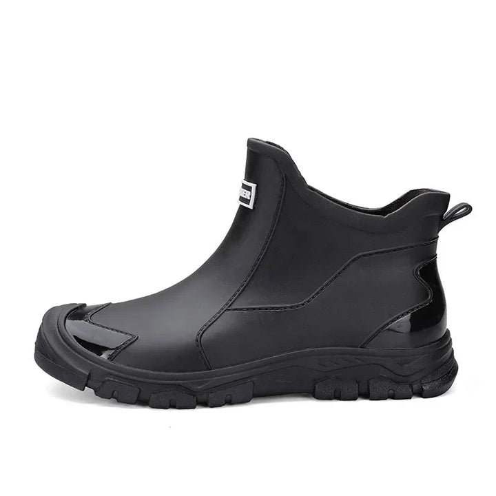 Black waterproof ankle rain boots with a rugged treaded sole and convenient rear pull tab for easy wear.