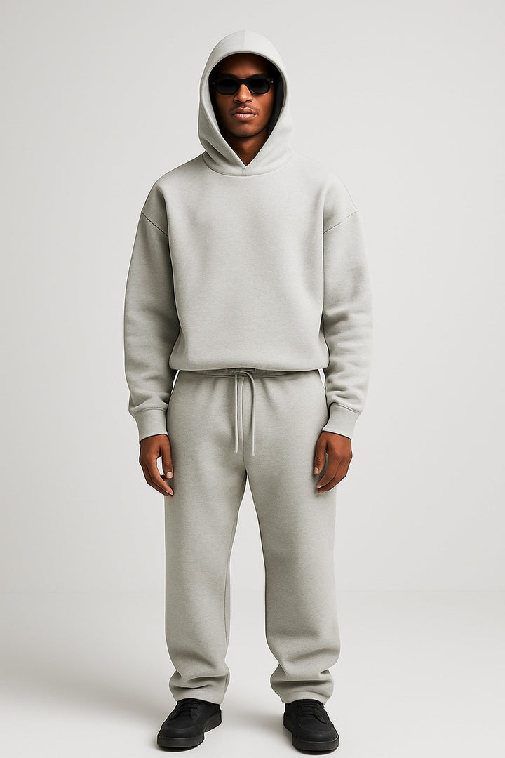 Man wearing a light grey cotton hoodie and matching drawstring joggers set.