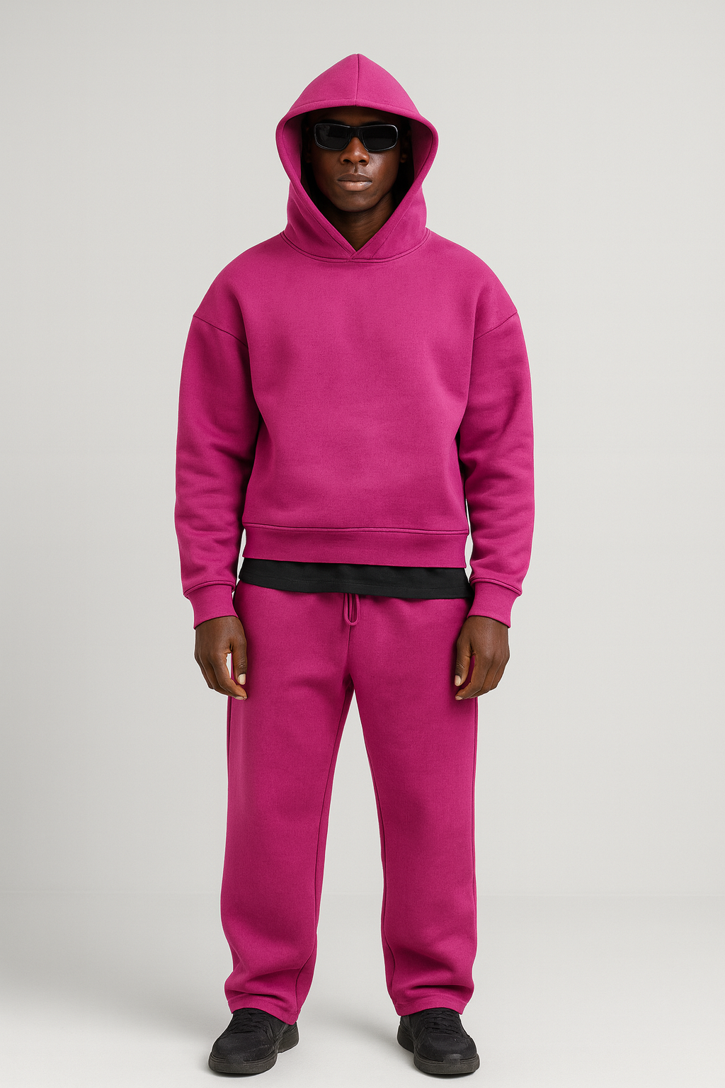 Man wearing a vibrant magenta cotton hoodie and matching drawstring joggers set.