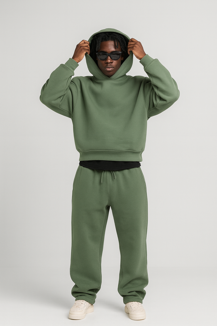 Man wearing a sage green cotton hoodie and matching drawstring joggers set.
