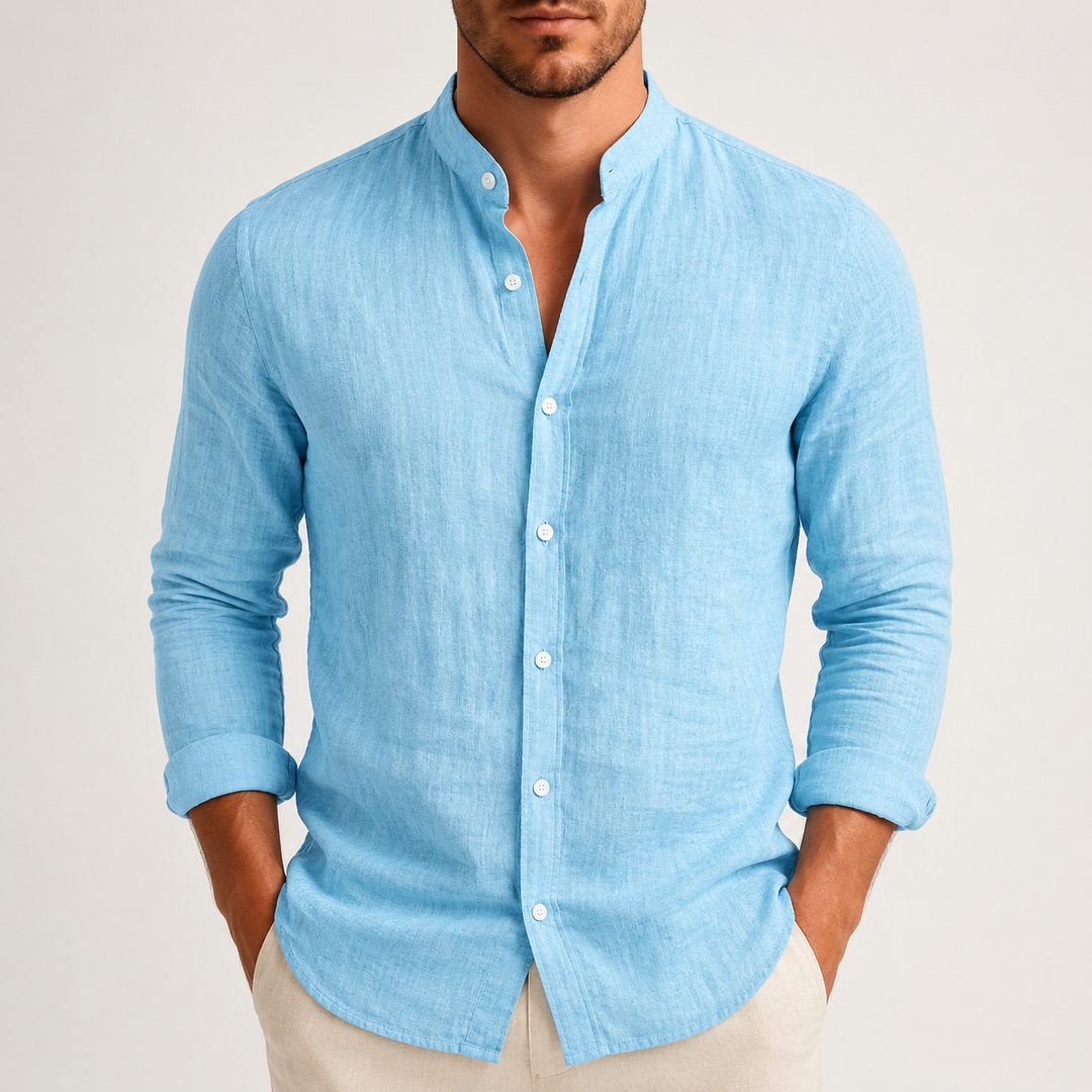 Man wearing a light blue, long-sleeve linen shirt with a grandad collar and button-up front, styled with beige trousers.