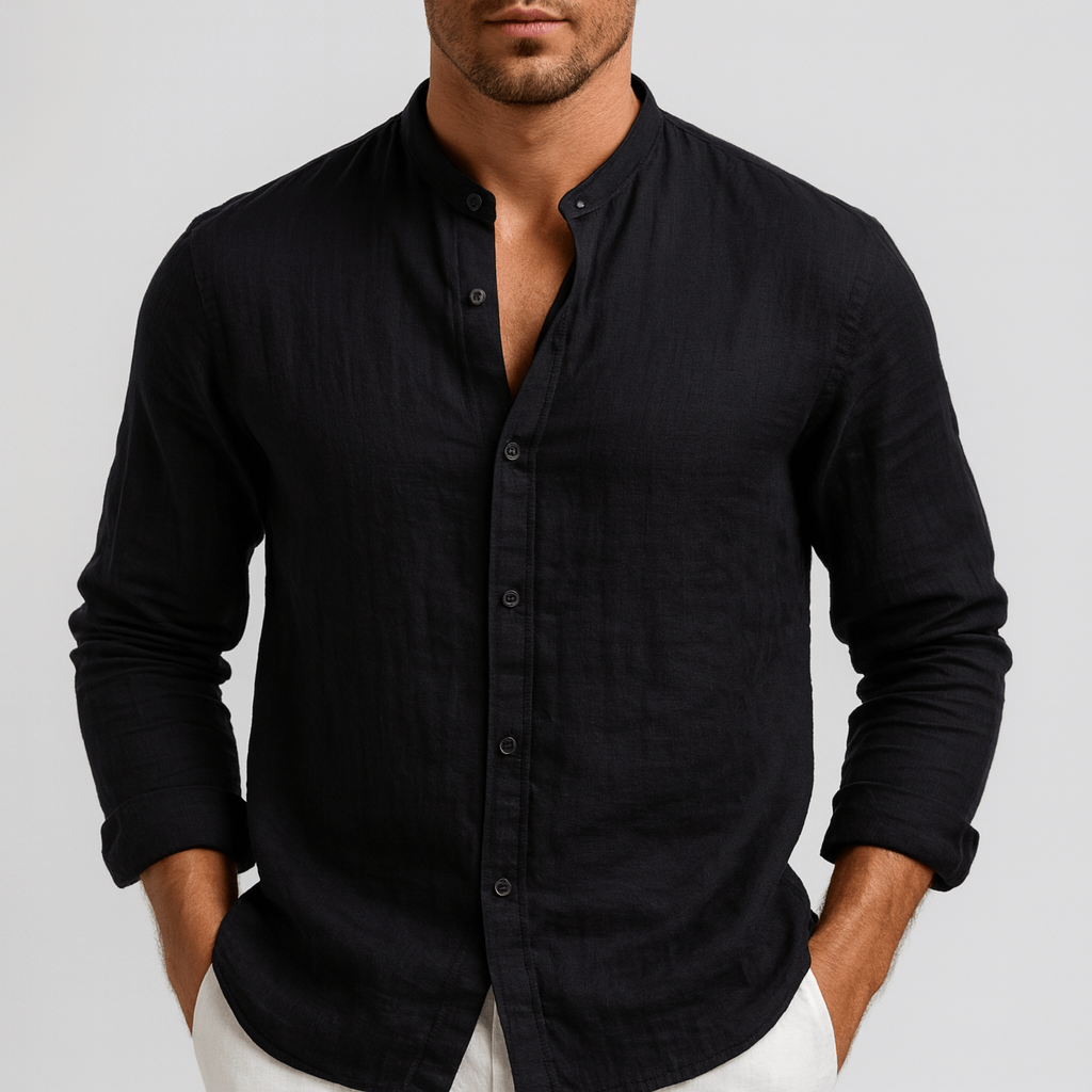 Man wearing a black long-sleeve linen shirt with a grandad collar and relaxed fit, styled with white trousers.