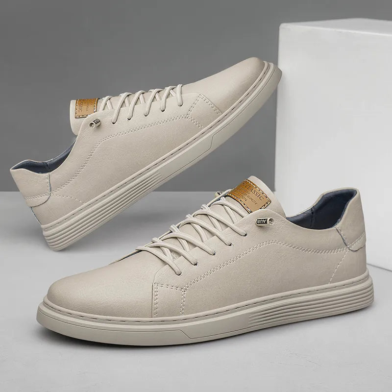 Beige low-top lace-up trainers with a smooth leather finish, tonal stitching, and a textured rubber sole.
