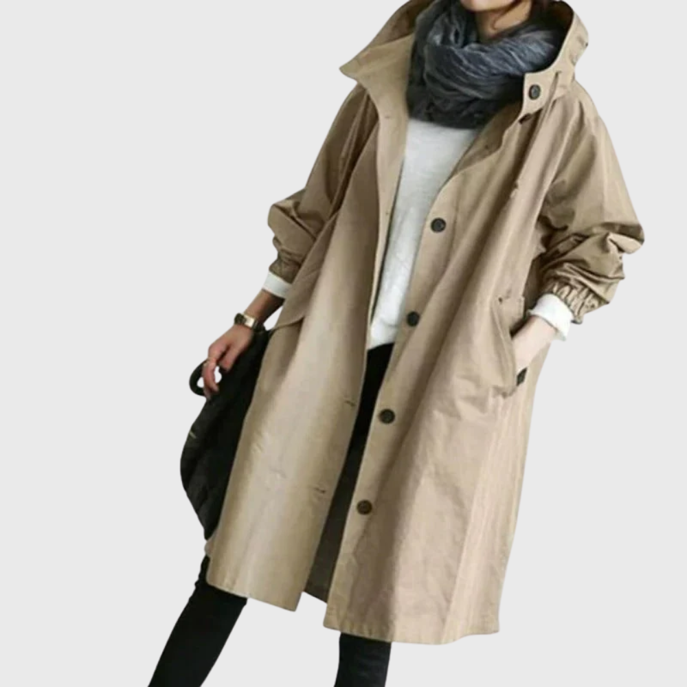 Beige oversized waterproof raincoat with a hood, button-front closure, and longline silhouette.