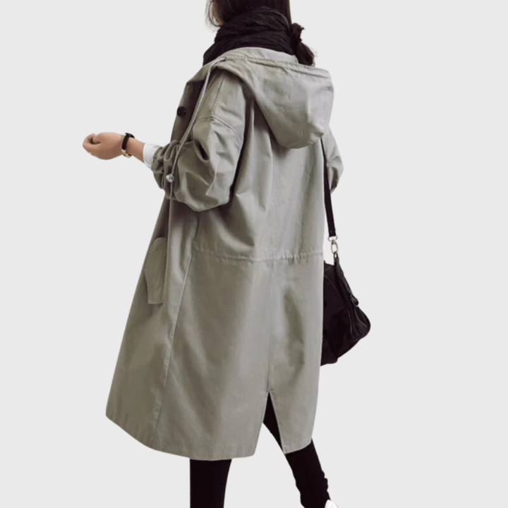 Sage green oversized hooded raincoat with a longline silhouette, button-front closure, and deep side pockets.