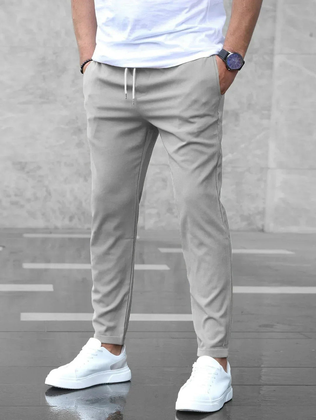 Men wearing light grey slim-fit joggers with an elasticated drawstring waist, side pockets, and a tapered silhouette.