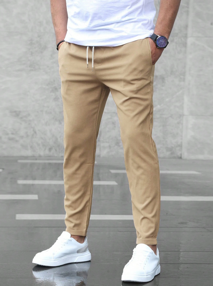 Men wearing slim-fit tan joggers with an elasticated drawstring waist, side pockets, and a tapered silhouette.