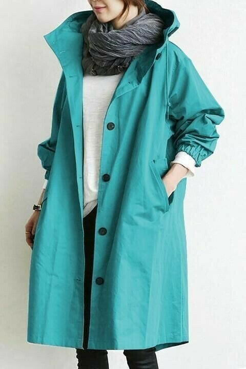 Teal longline windbreaker jacket with an adjustable hood, button-front closure, and elasticated cuffs.