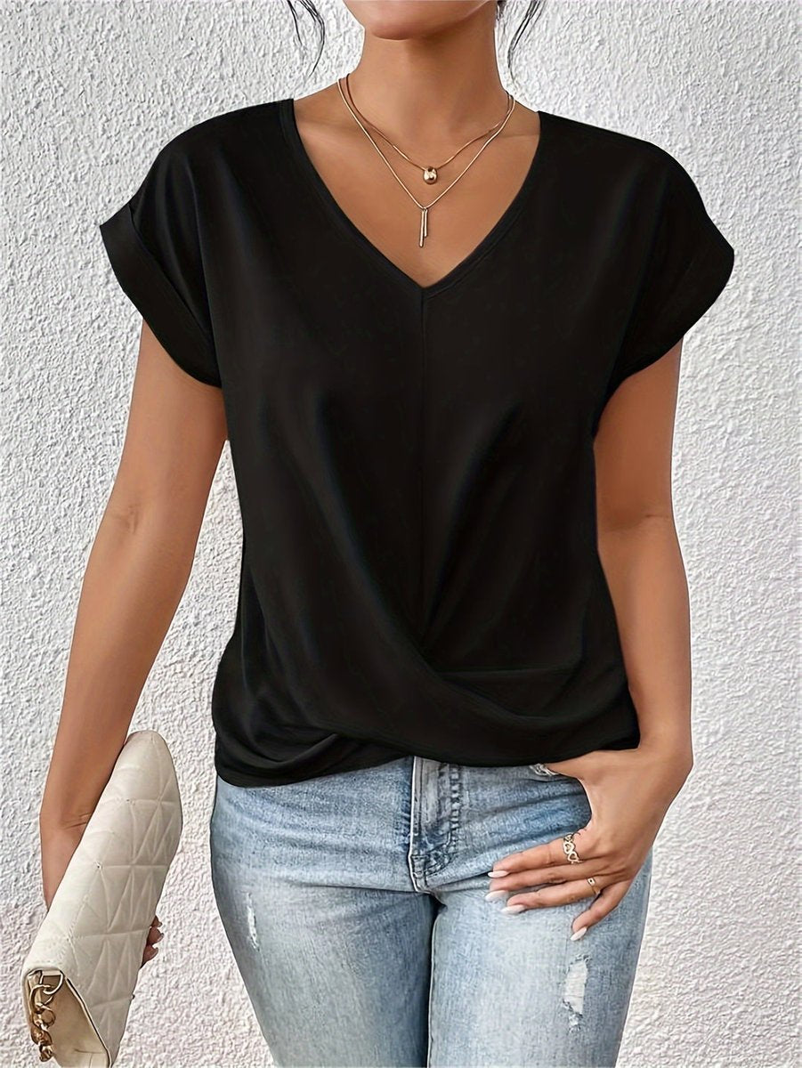 Black V-neck top with cap sleeves and a flattering twist hem detail, styled with light wash jeans.