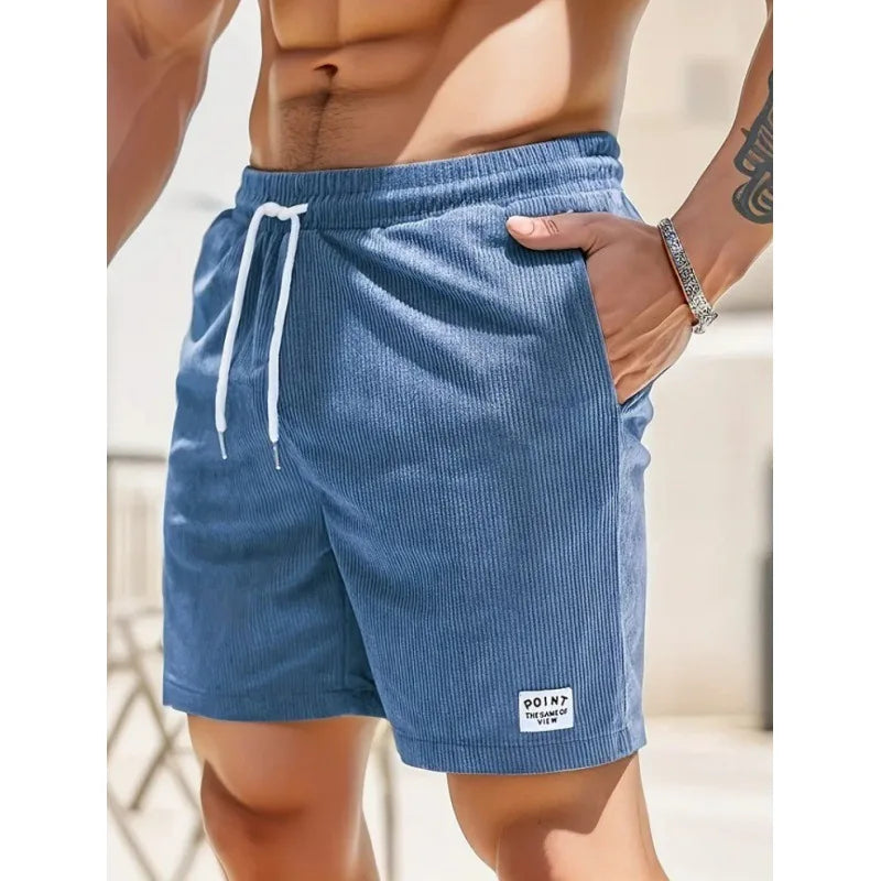 Blue corduroy drawstring shorts with side pockets and a small branded patch on the hem for a relaxed casual fit.