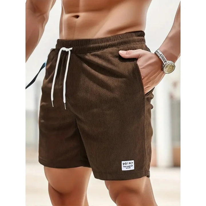 Brown corduroy men's drawstring shorts with side pockets and a small branded patch on the hem.