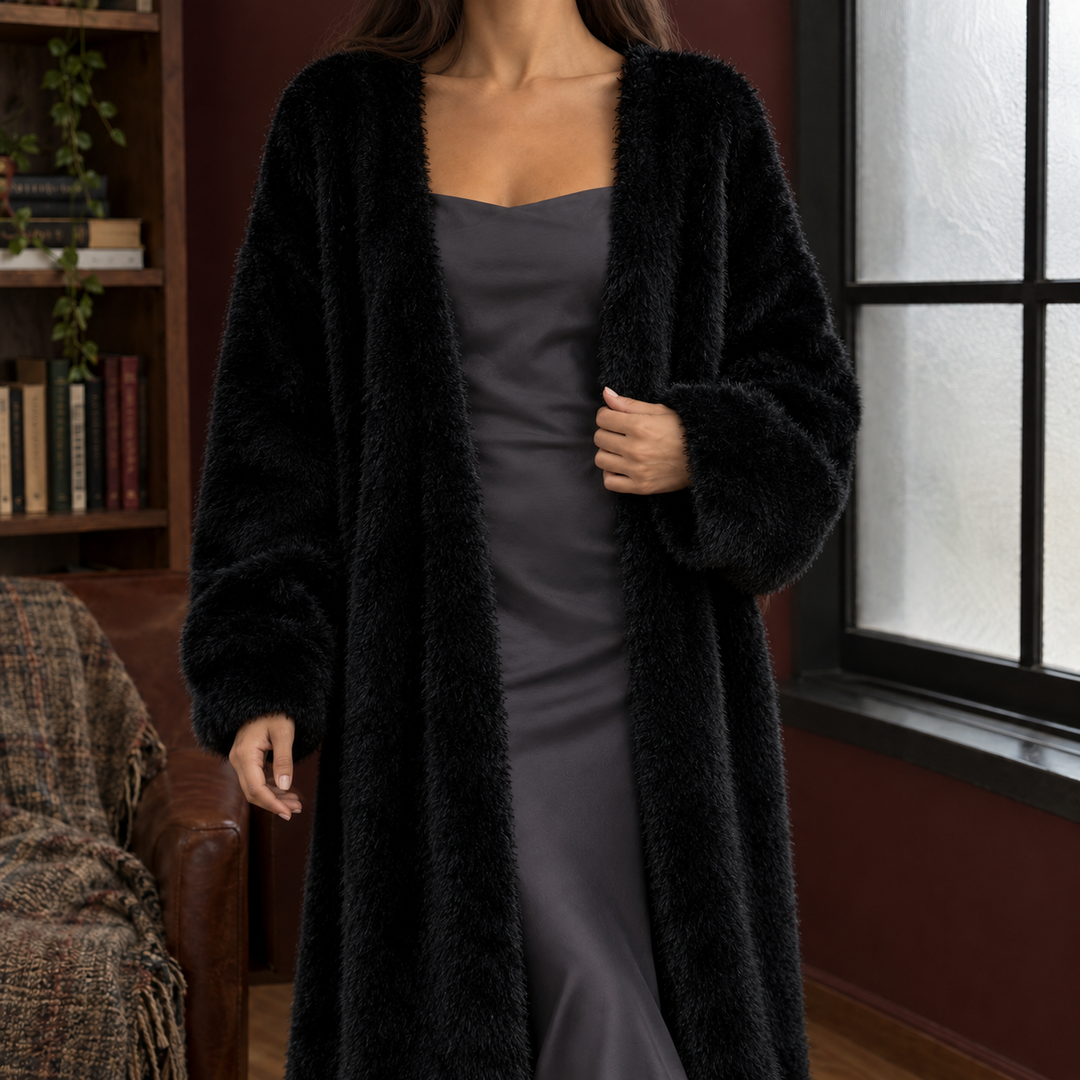Woman wearing a black longline plush knit cardigan with an open front and voluminous sleeves for a cozy, relaxed fit.