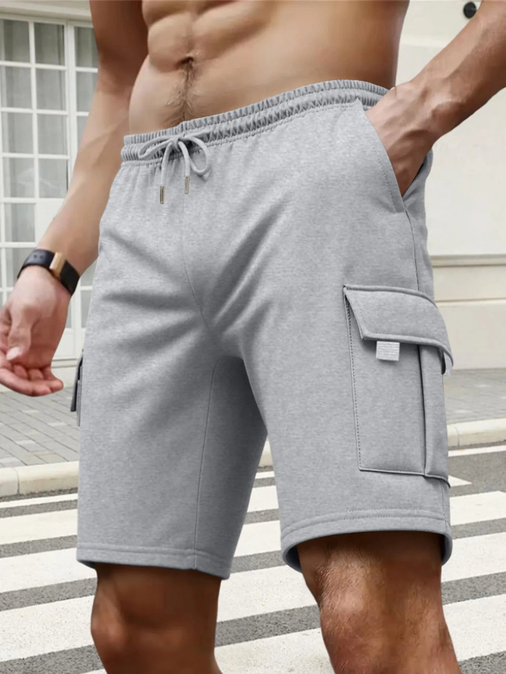 Grey men's knee-length cargo shorts with an elasticated drawstring waist and side flap pockets in soft fabric.