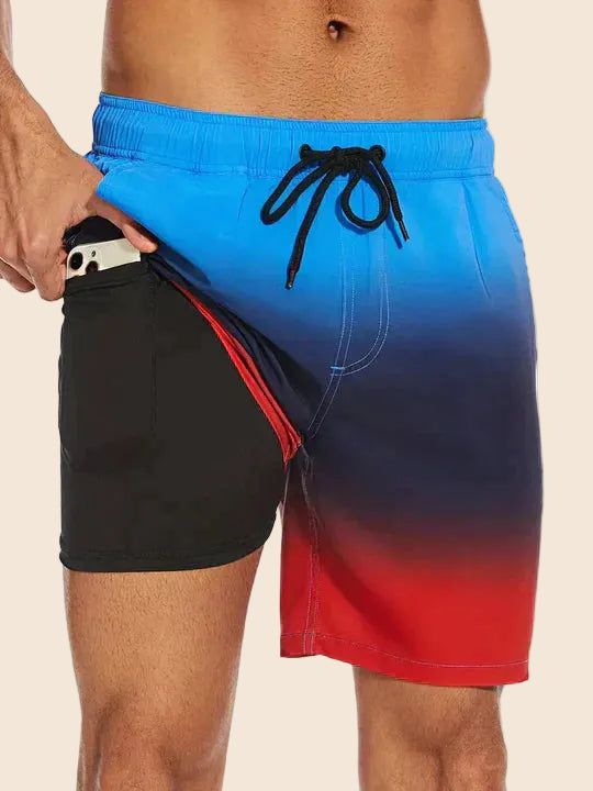 Blue to red ombre men's swim shorts with a black drawstring waist and a black inner liner featuring a side phone pocket.