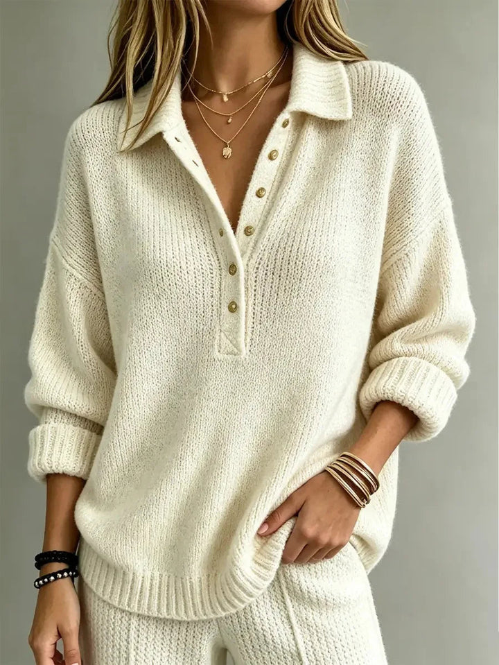Cream-colored knit polo jumper featuring a pointed collar, partial button placket, dropped shoulders, and ribbed trim.
