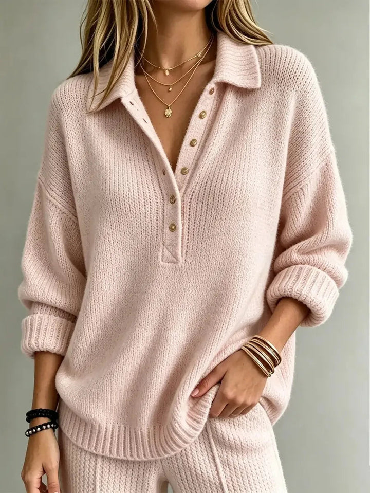 Soft pink textured knit polo jumper with a pointed collar, button placket, dropped shoulders, and ribbed cuffs.