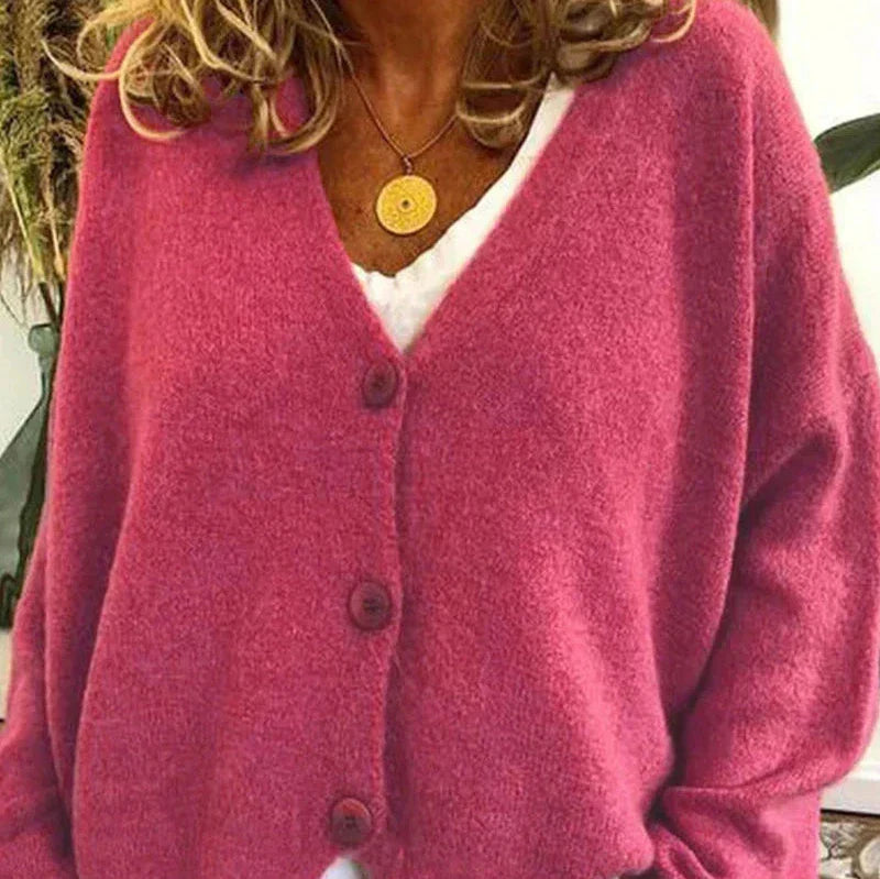 Soft pink V-neck knit cardigan with a button-front closure and relaxed, cozy fit.