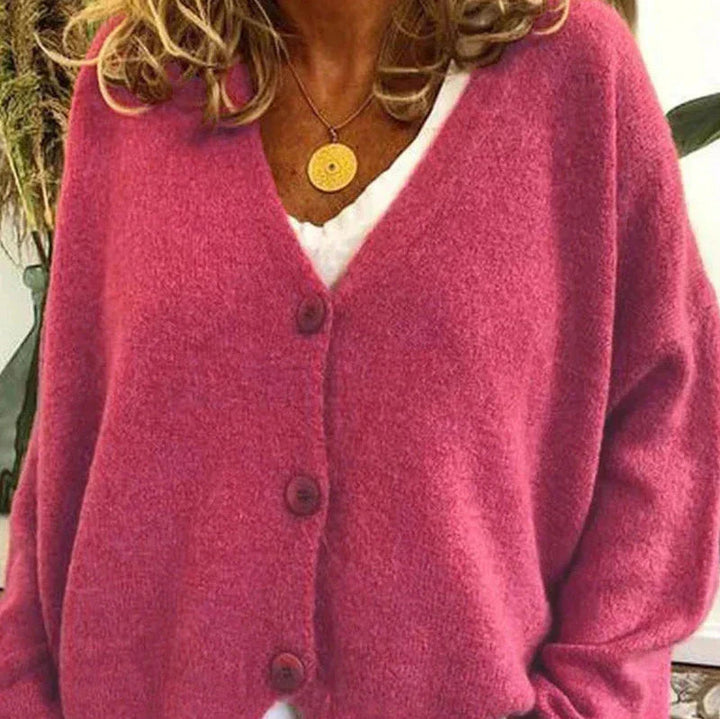 Soft pink V-neck knit cardigan with a button-front closure and relaxed, cozy fit.