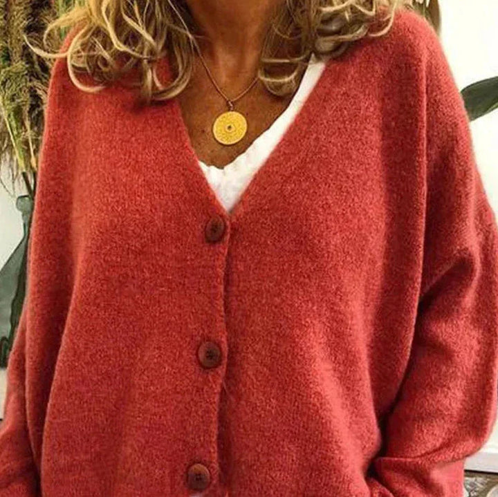Soft rust-colored knit V-neck cardigan with a button-front closure and relaxed, comfortable fit.