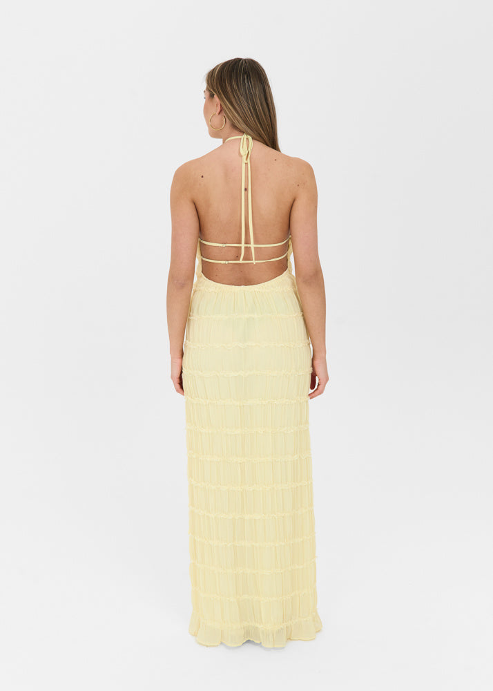 Back view of a cream-colored, textured tiered maxi dress with a halter neckline and open back design.