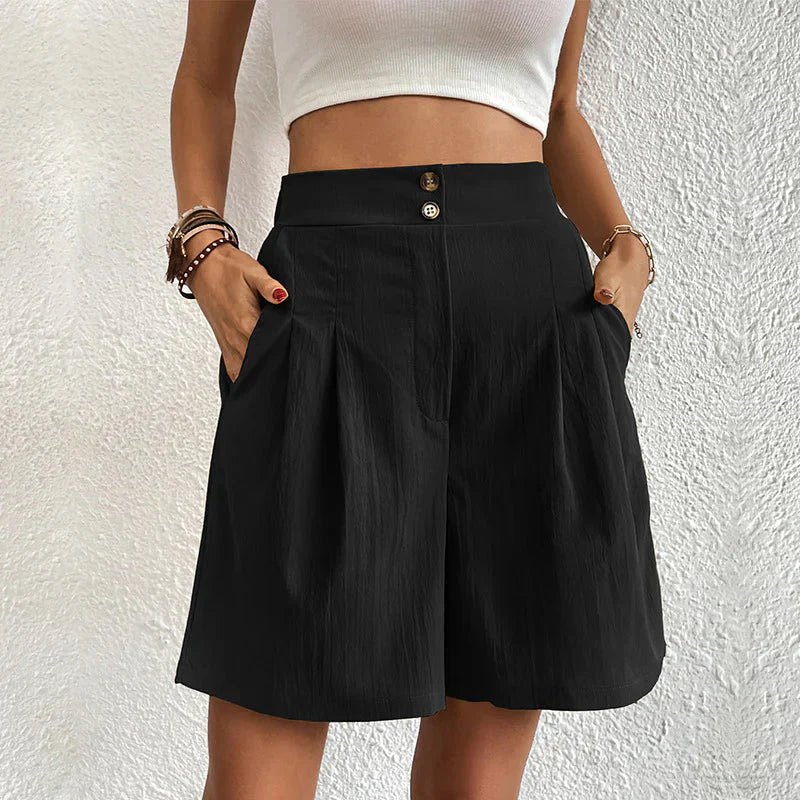 Black high-waisted pleated shorts with a double-button waistband, wide-leg fit, and side pockets.