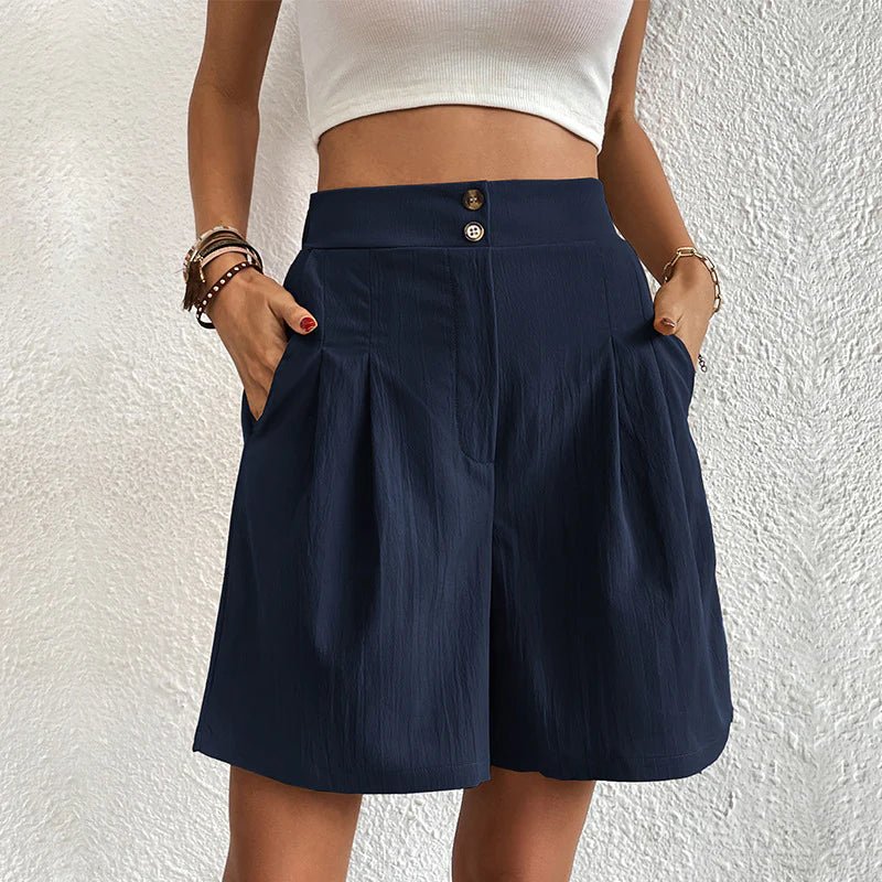 Navy blue high-waisted pleated shorts with a double-button waistband and side pockets.