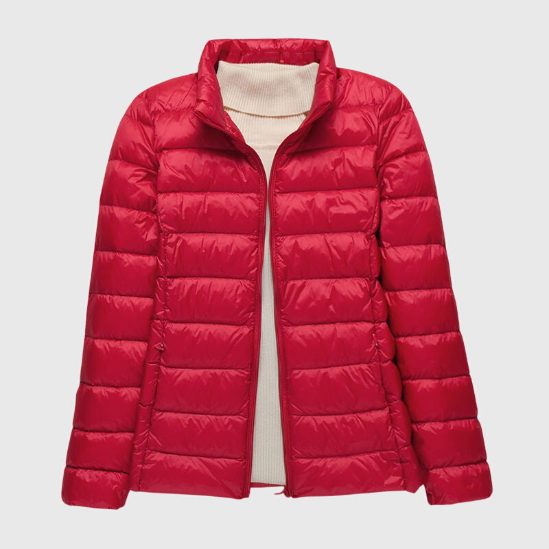 Women's lightweight red quilted jacket with a stand-up collar and full-length zip, worn over a cream turtleneck.